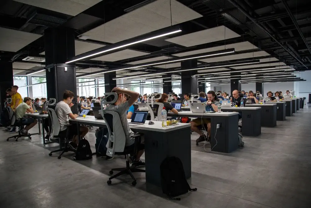 Busy open-plan office with rows of people working at desks